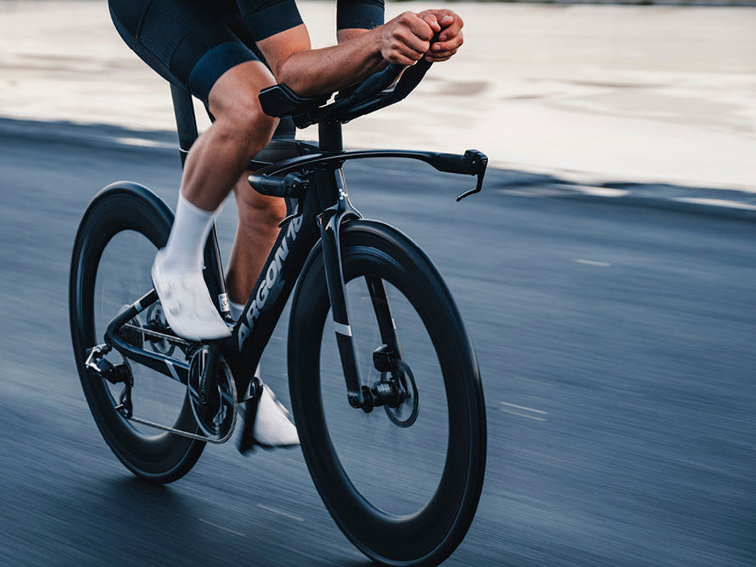 Triathlete racing the Argon 18 E-119 Tri+ Disc on an open road