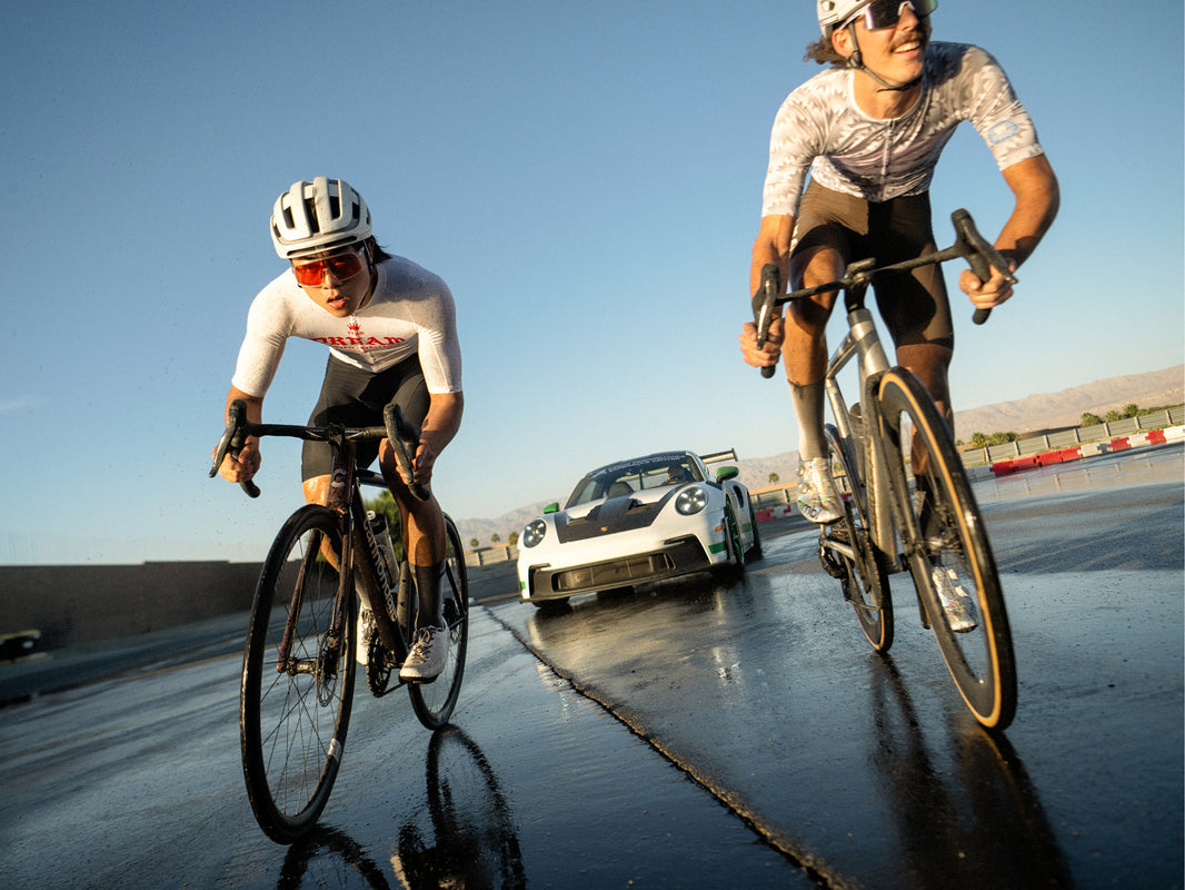 Two riders racing Cannondale CAAD14 bikes on a coastal road