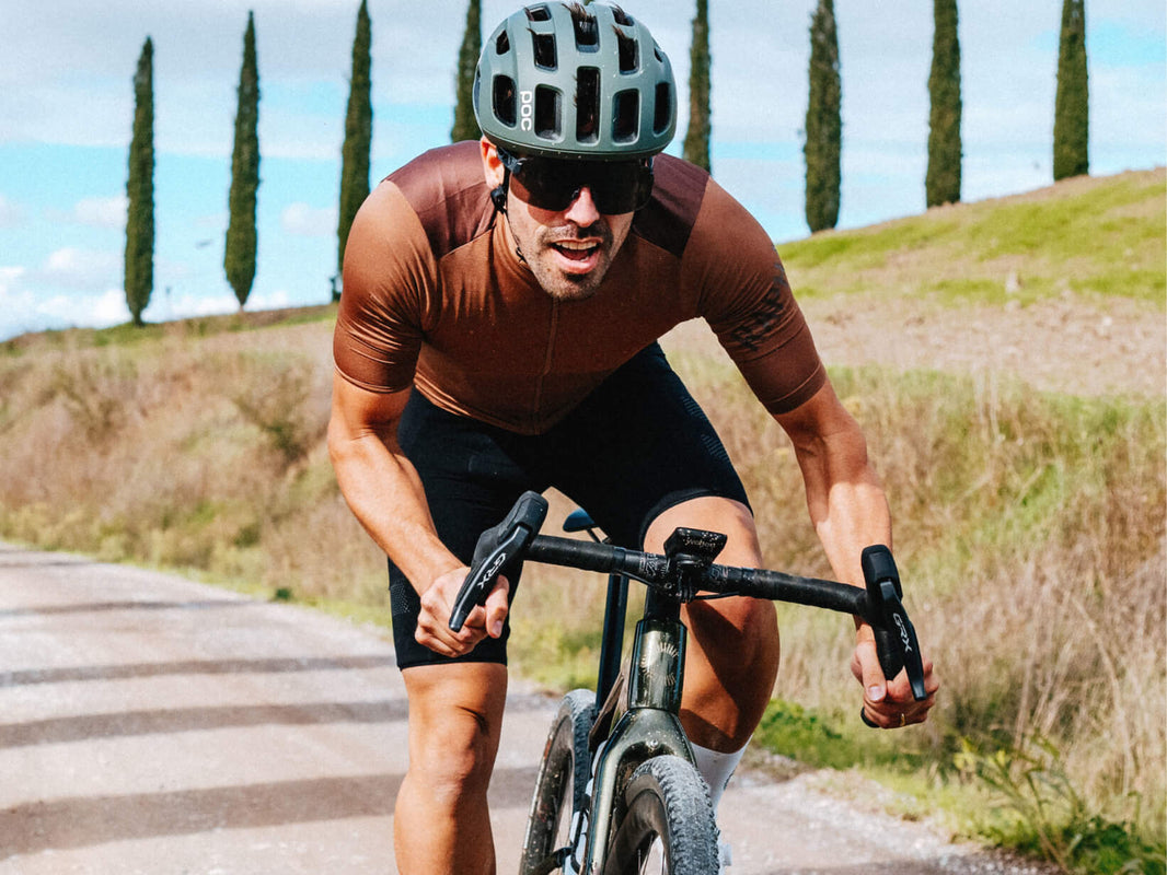 Rider on a Cannondale Topstone Carbon on a cypress-lined gravel road